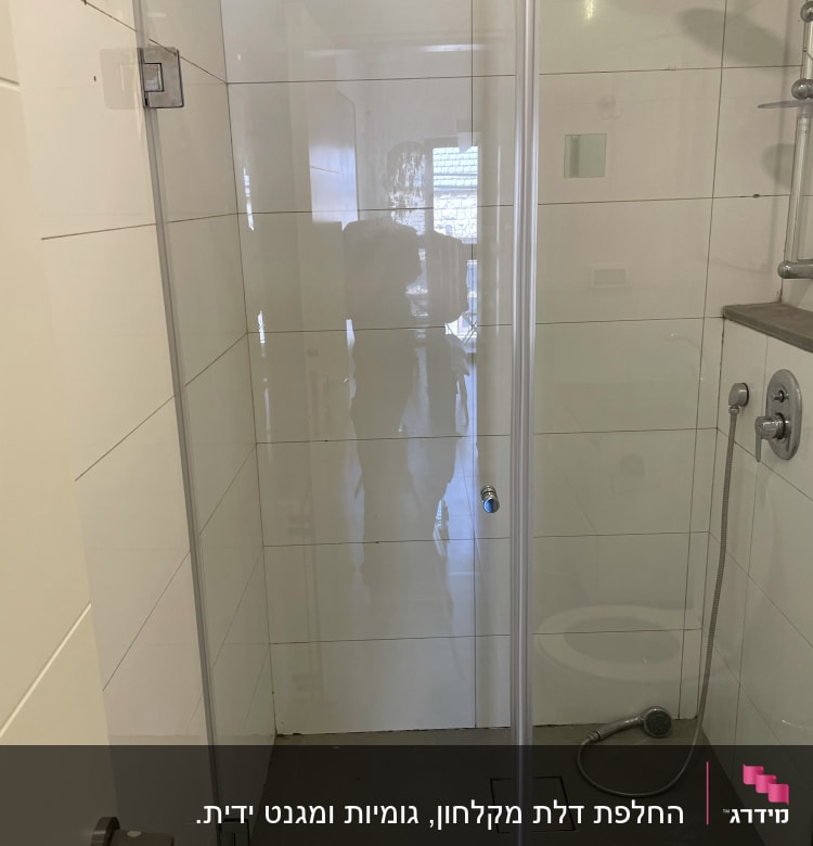 מקלחת עם דלת זכוכית, ראש מקלחת וצינור מים